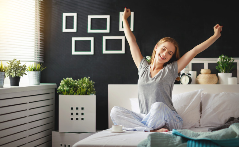 young woman woke up in the morning in the bedroom by the window with her back