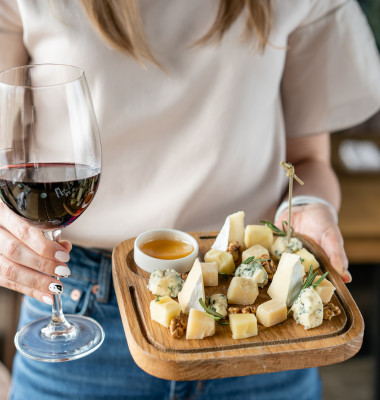 Girl,Holding,Glass,Red,Wine,And,Wooden,Plate,With,Cheese.