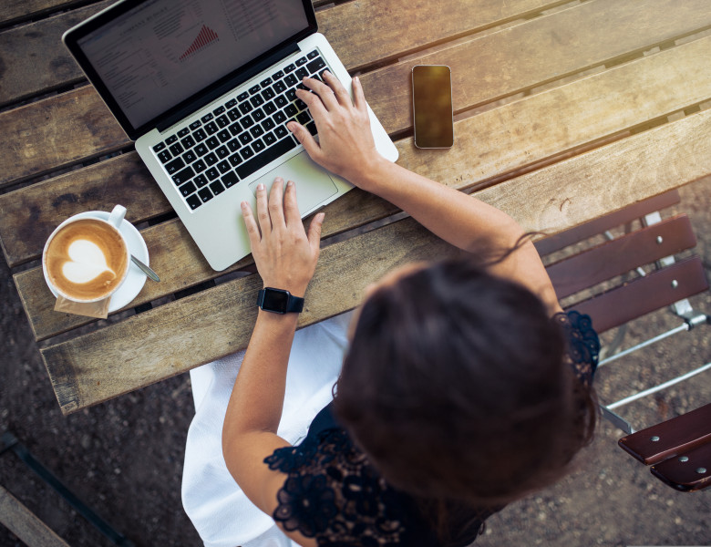 Top,View,Of,Female,Using,Her,Laptop,At,A,Cafe.