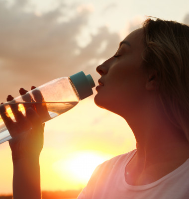 Young,Woman,Drinking,Water,To,Prevent,Heat,Stroke,Outdoors,At