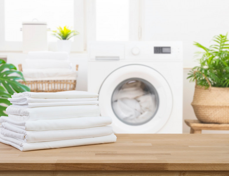 Stack,Of,Clean,Folded,Laundry,Bedding,Sheets,On,Wooden,Table