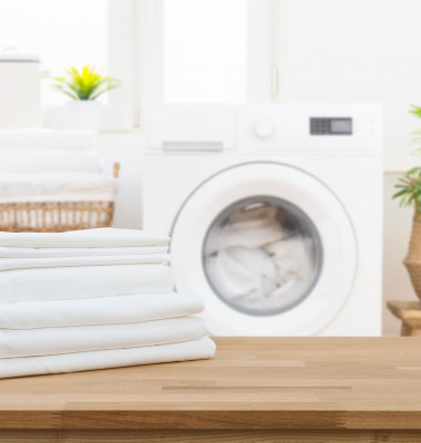 Stack,Of,Clean,Folded,Laundry,Bedding,Sheets,On,Wooden,Table