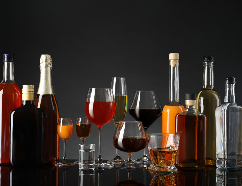 Bottles,And,Glasses,With,Different,Alcoholic,Drinks,On,Table,Against