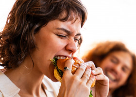 femeie care mananca un burger