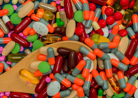 Pile of colorful pills and wood spoon. Medicine, vitamins, supplement and minerals. Antibiotics drug resistance and drug use with reasonable concept.