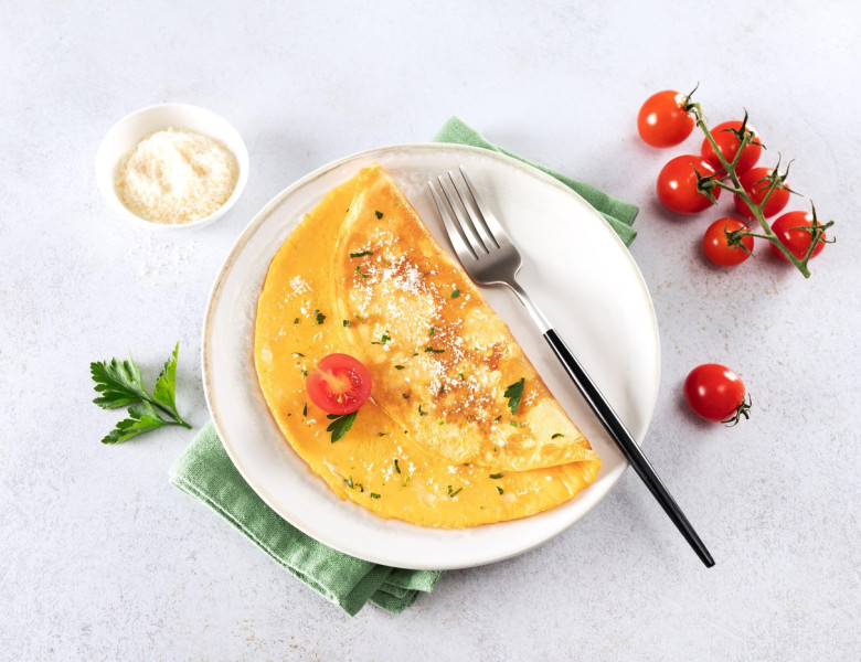 Eggs omelette with cheese, tomato and parsley on a white background. Top view.
