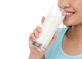 femeie care bea un pahar cu lapte