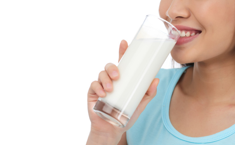 femeie care bea un pahar cu lapte