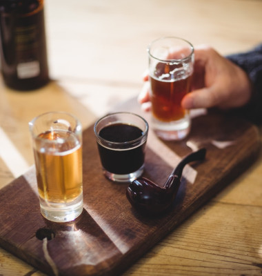 Cropped image of mature man taking a glass of alcohol