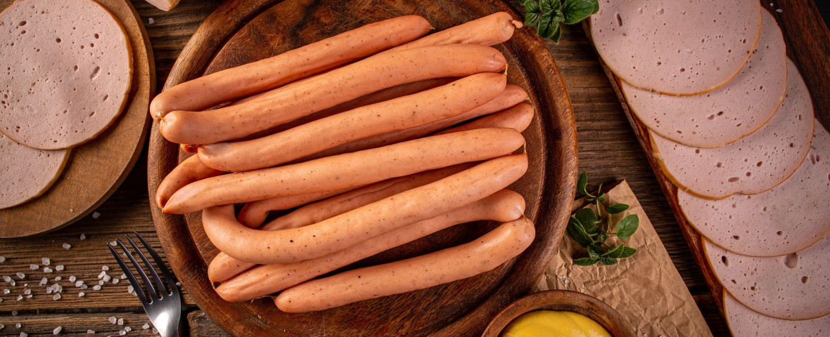 Flat lay shot of Frankfurter sausages on rustic wooden cutting board