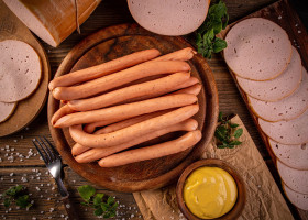 Flat lay shot of Frankfurter sausages on rustic wooden cutting board