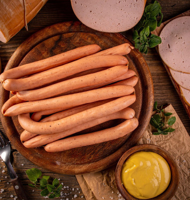 Flat lay shot of Frankfurter sausages on rustic wooden cutting board
