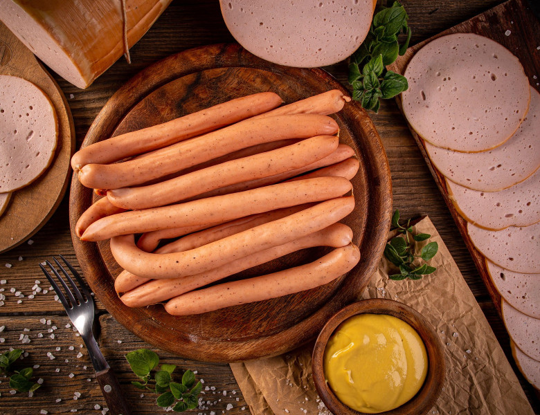 Flat lay shot of Frankfurter sausages on rustic wooden cutting board