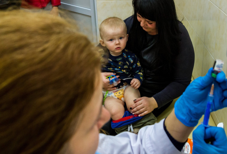Copil așteptând cu mama să fie vaccinat, imunizare