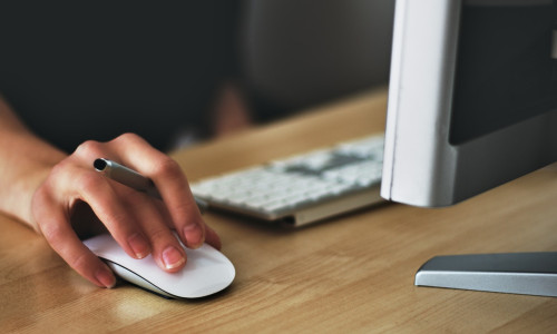 Mână de femeie pe mouse de calculator, lucrează la birou