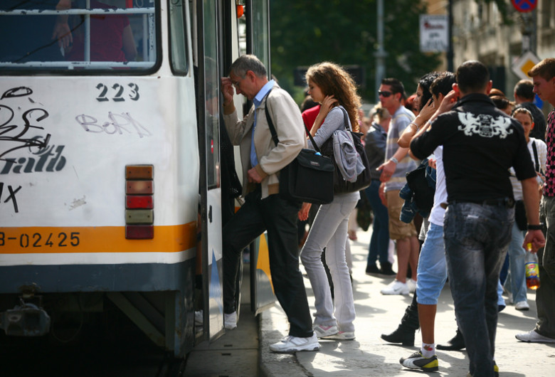 Oameni urcă în tramvai