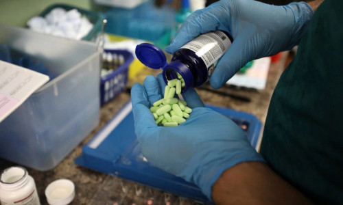 Medic pune pastile, medicamente, tratamente din borcan în mână