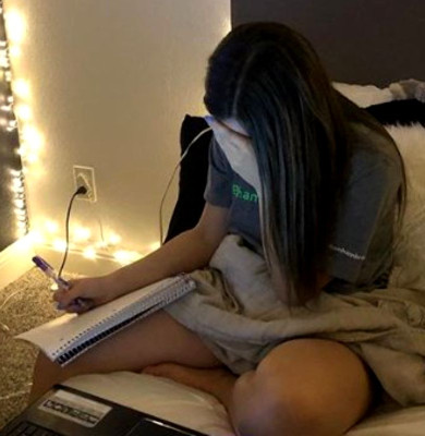 Adolescentă scrie pe caiet