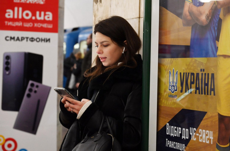 December 12, 2023, Kyiv, Ukraine: A young woman is using her mobile phone in the city's subway in Kyiv, Ukraine, on December 12, 2023, amid Russia's invasion of Ukraine. Since the morning, Kyivstar, a prominent and large Ukrainian telecommunications company, has been experiencing a large-scale failure. Users are unable to make or receive calls and use internet services due to a powerful hacker attack on the operator's infrastructure, according to local media.,Image: 828917511, License: Rights-managed, Restrictions: * France Rights OUT *, Model Release: no