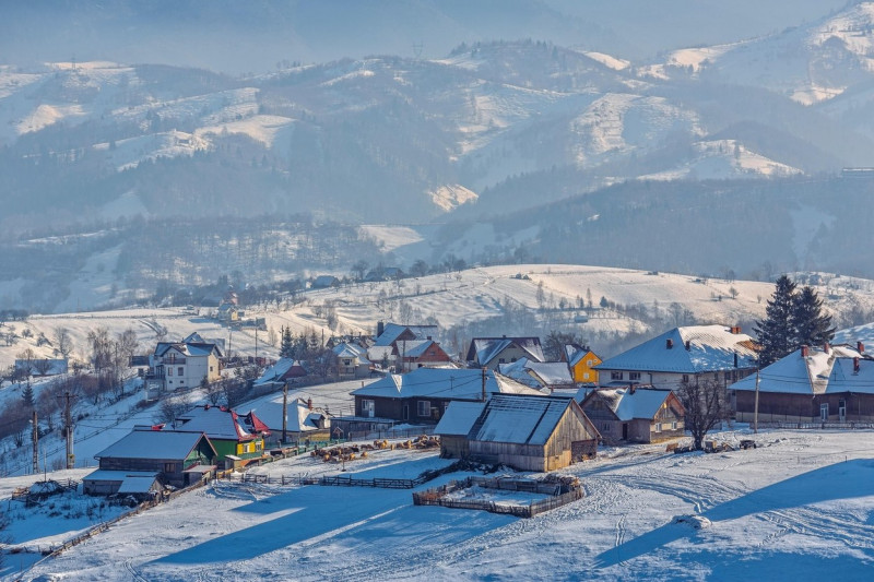 Countryside landscape with traditional Romanian village in the valleys of the Bucegi mountains on a sunny cold winter morning in Pestera, Brasov county, Transylvania region, Romania.,Image: 323158669, License: Royalty-free, Restrictions: , Model Release: no