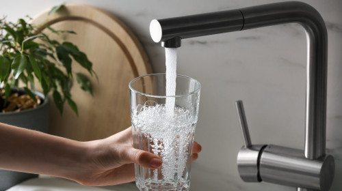 Woman,Filling,Glass,With,Tap,Water,From,Faucet,In,Kitchen,