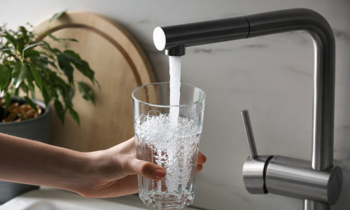 Woman,Filling,Glass,With,Tap,Water,From,Faucet,In,Kitchen,