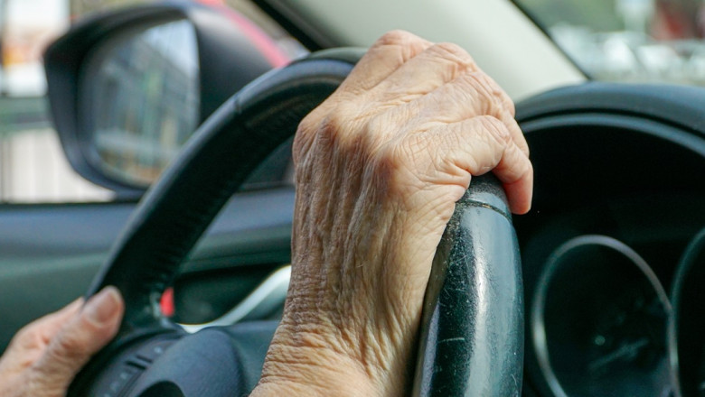 View,Of,Old,Hands,On,A,Car's,Steering,Wheel,,Driving