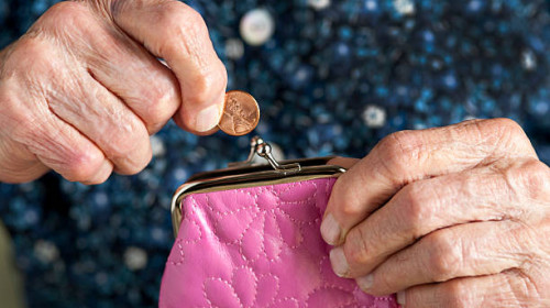 Penny being deposited or pulled out of a purse by a pair of elderly hands.