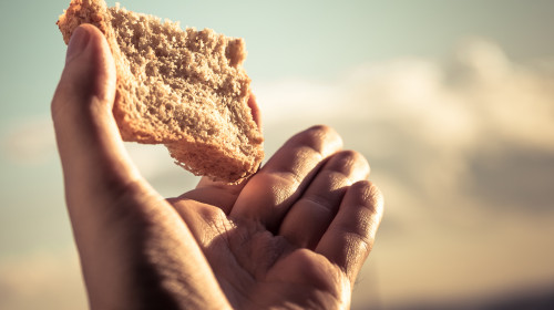 Hand,Hold,A,Slice,Of,Bread,Over,Sky,Background.,Color