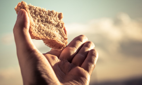 Hand,Hold,A,Slice,Of,Bread,Over,Sky,Background.,Color