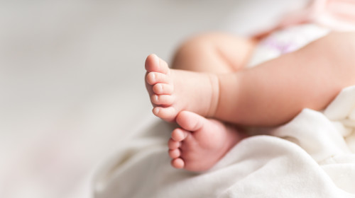 New,Born,Baby,Feet,On,White,Blanket