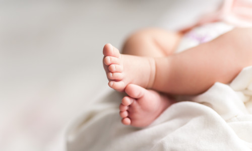 New,Born,Baby,Feet,On,White,Blanket