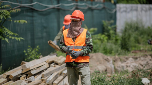 Bucharest, Romania - May 14, 2020: Asian construction workers on a construction site in Bucharest.