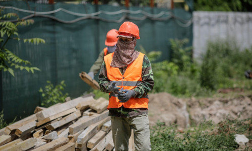 Bucharest, Romania - May 14, 2020: Asian construction workers on a construction site in Bucharest.