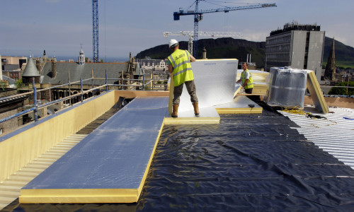 roofer working on roof lying insulation