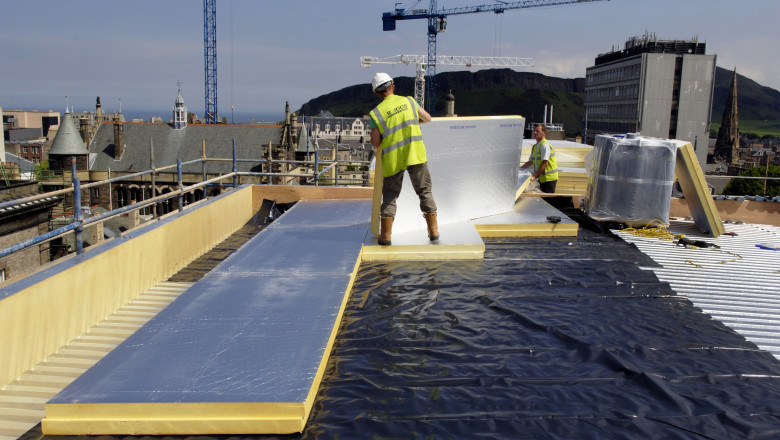 roofer working on roof lying insulation