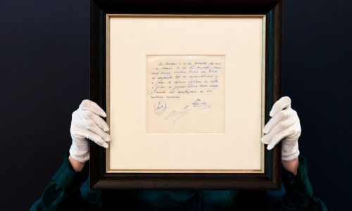 A Bonhams staff member holds up a napkin on which a written commitment was made to Lionel Messi, when he was 13-years-old, for a contract from FC Barcelona in December 2000, on display at Bonhams in London before it is offered at auction. Picture date: We
