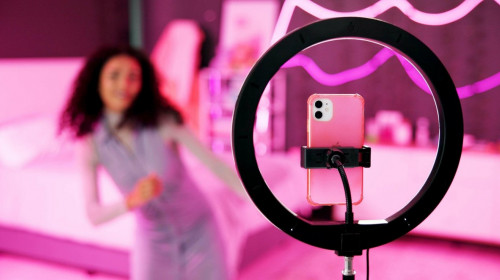 Girl, dancer and ring light for live stream for social media, connection or audience for online. Female person, influencer and bedroom with tripod for