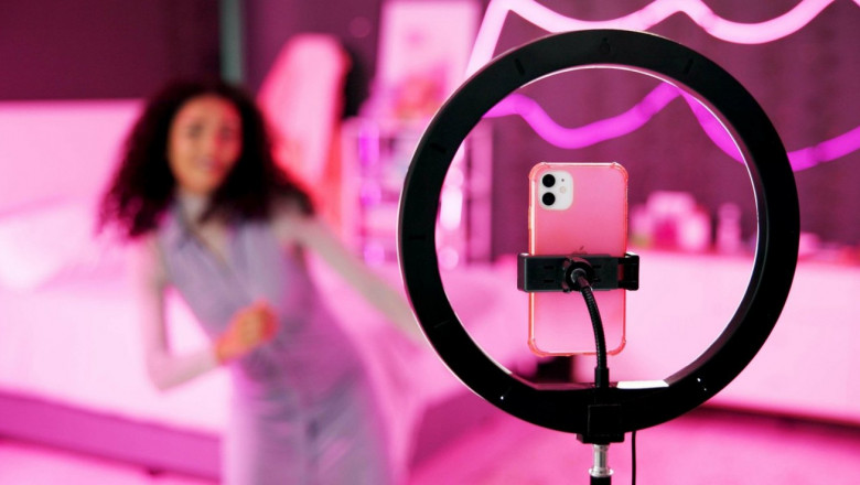 Girl, dancer and ring light for live stream for social media, connection or audience for online. Female person, influencer and bedroom with tripod for