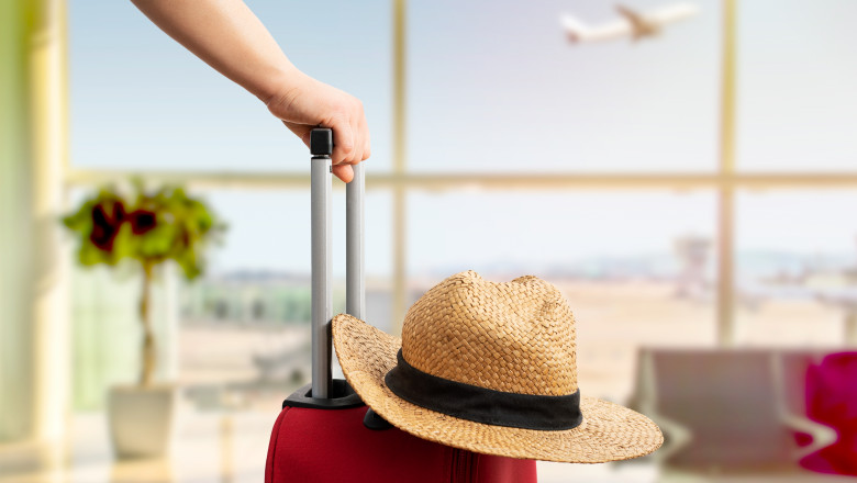 Woman,With,Red,Suitcase,And,Hat,Standing,At,Airport.tourism,Concept