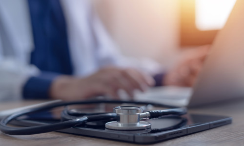 Close-up,Of,Doctor,Working,On,Laptop,Computer,With,Digital,Tablet