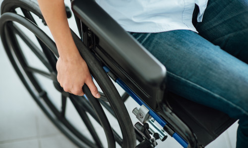 Woman,In,Wheelchair's,Hand,On,Wheel,Close,Up,,Disability,And