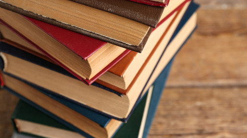 Stack,Of,Old,Hardcover,Books,On,Wooden,Background,,Closeup