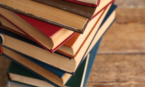 Stack,Of,Old,Hardcover,Books,On,Wooden,Background,,Closeup