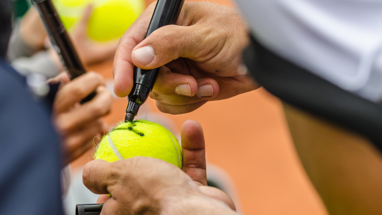 Tennis,Player,Signs,Autograph,On,A,Tennis,Ball,After,Win,