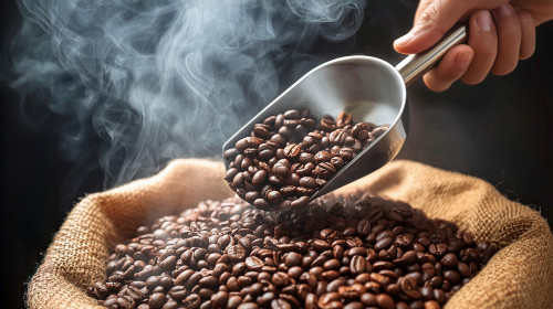 Hand,Holding,A,Ladle,Scooping,Up,Roasted,Coffee,Beans,From