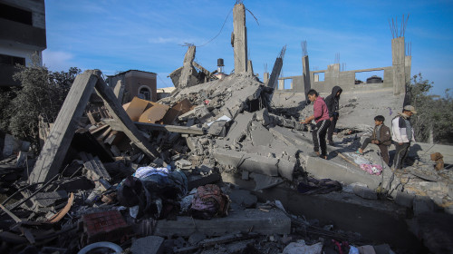 People inspect the destroyed house of the Al bayomi family in Al Nusairat refugee camp, central Gaza