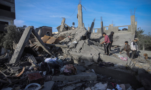 People inspect the destroyed house of the Al bayomi family in Al Nusairat refugee camp, central Gaza