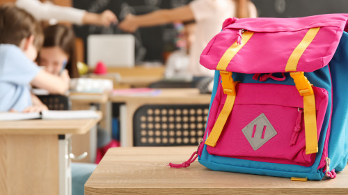 Child's,Backpack,On,Desk,In,Classroom