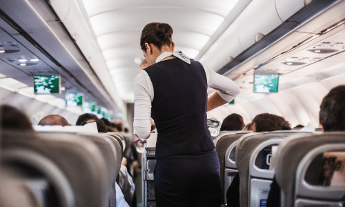 Interior,Of,Airplane,With,Passengers,On,Seats,And,Stewardess,In